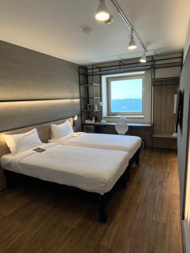 a hotel room with two beds and a window at Ibis Istanbul Zeytinburnu in Istanbul