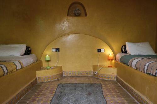 a room with two beds and two lamps in it at Villa Grenadine in Essaouira