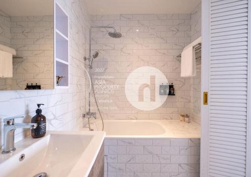 hovoh homes Bugis Rochor في سنغافورة: حمام أبيض مع حوض ومغسلة
