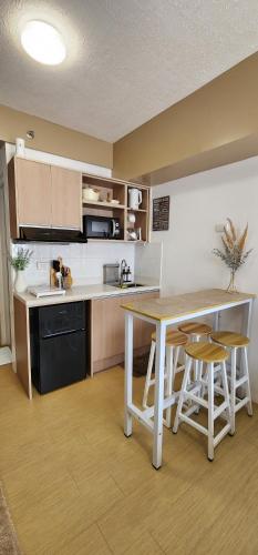 a kitchen with a table and a table and chairs at Studio Unit for Family @ Aspira in Cagayan de Oro