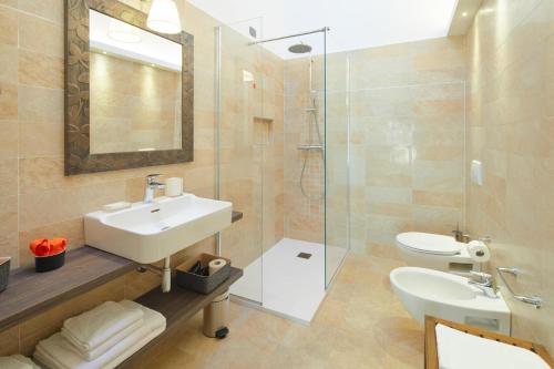 een badkamer met een wastafel, een toilet en een douche bij Residenza ai Ferrari - Appartamento Lilium in Riva del Garda
