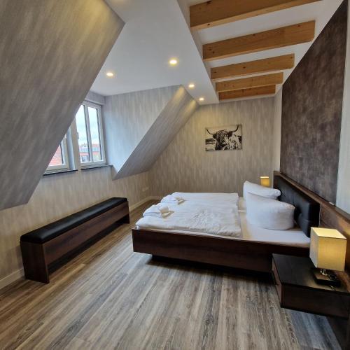 a bedroom with a large bed and a staircase at DM Hotels & Apartments - Apartment Rasenweg in Dingelstädt