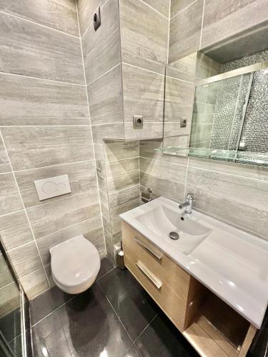 une salle de bain avec des toilettes blanches et un lavabo dans l'établissement La Dunette - Splendide Vue port avec les bateaux, à Dieppe