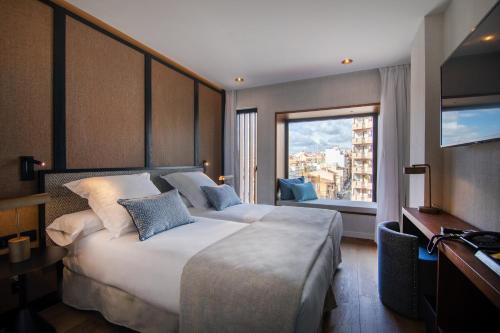 une chambre d'hôtel avec un grand lit et une fenêtre dans l'établissement JS Palma Plaza, à Palma de Majorque
