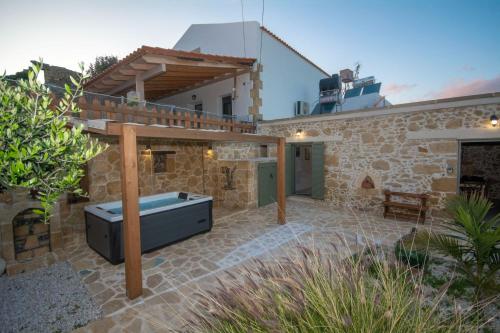 a stone house with a bath tub on a patio at Pamelas House with Jacuzzi in Kissamos