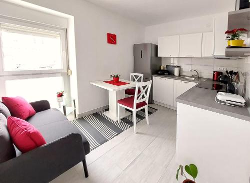 een keuken en een woonkamer met een bank en een tafel bij Apartment Oliva in Knin