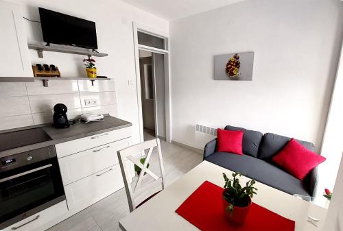 een kleine woonkamer met een bank en een tafel bij Apartment Oliva in Knin