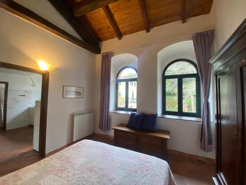 1 dormitorio con 1 cama y 2 ventanas en Lunigiana Experience en Pontremoli