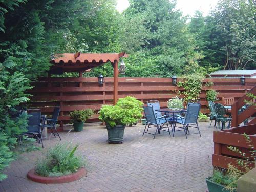 a patio with a table and chairs and a wooden fence at The Hill Hotel in Dumfries