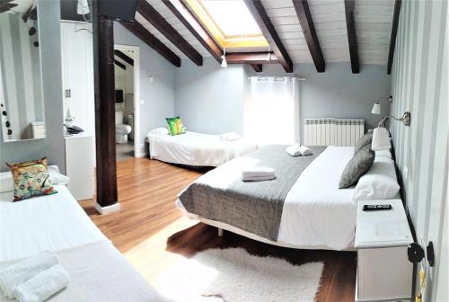 a bedroom with two beds and a skylight at Casa Rural Madera y Sal in Salinas de Añana