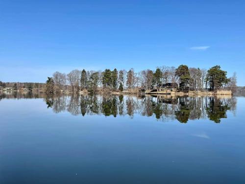duże jezioro z drzewami odbijającymi się w wodzie w obiekcie Escape to Your Very Own Private Island - Just 30 Minutes from Stockholm w mieście Svartsjö