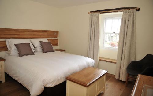 a bedroom with a large bed and a window at No 3 The Forge Coniston in Coniston