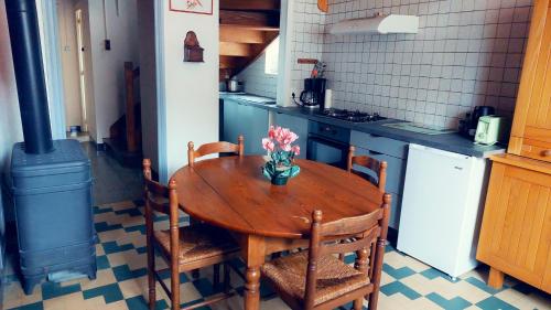 a kitchen with a wooden table with a vase of flowers on it at Maison de 3 chambres avec jardin clos et wifi a Charix in Charix