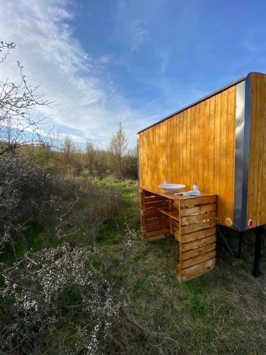 a wooden building with a desk in a field at Maringotka Za Trnkou in Točník