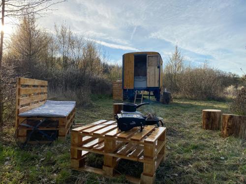 a tent and a table and a chair in a field at Maringotka Za Trnkou in Točník