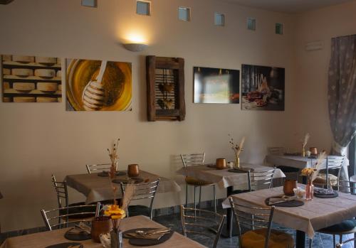 um restaurante com mesas e cadeiras e pinturas na parede em Essenza Hotel em Verrès