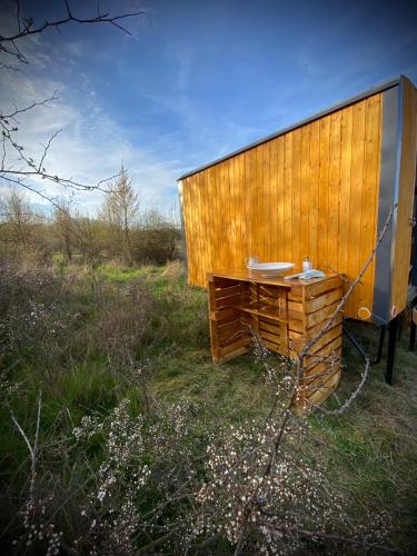 a wooden building in a field with a sink at Maringotka Za Trnkou in Točník
