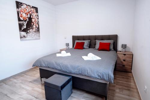 a bedroom with a large bed with red pillows at Apartman Ružić in Sveti Ivan Žabno