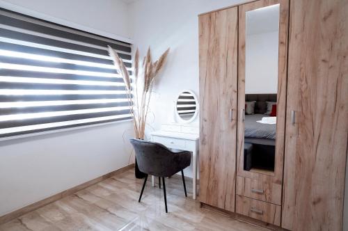 a bedroom with a black chair and a mirror at Apartman Ružić in Sveti Ivan Žabno