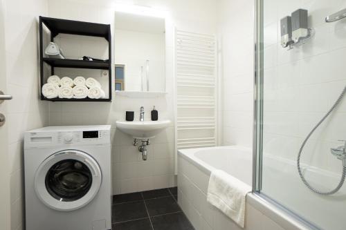 uma casa de banho com uma máquina de lavar roupa e um lavatório em Aesthetic newly renovated apartment located near Belvedere Castle, 15 minutes from Stephansplatz em Viena