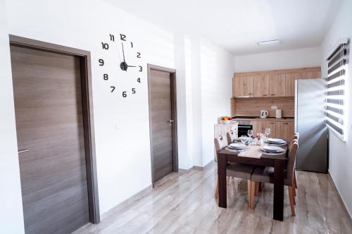 a kitchen with a table and a clock on the wall at Apartman Ružić in Sveti Ivan Žabno