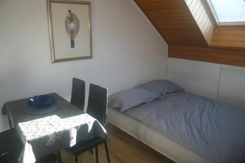 Dormitorio pequeño con cama y mesa en Savinja River Residence, en Ljubno