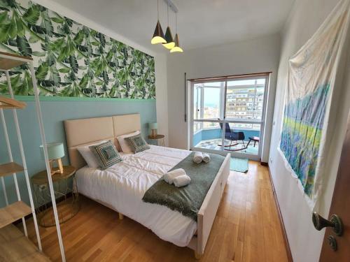 a bedroom with a large bed and a large window at Cozy Apartment in central Almada w Swing Chairs in Almada