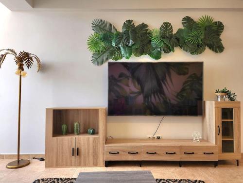 Cozy Apartment in central Almada w Swing Chairs في ألمادا: غرفة معيشة مع تلفزيون بشاشة مسطحة على جدار