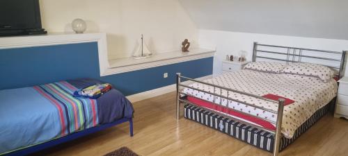 a childs bedroom with a crib and blue walls at Maison Ensoleillee - in Gesnes-le-Gandelin