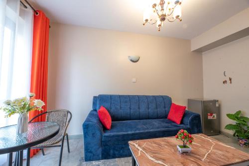 ein Wohnzimmer mit einem blauen Sofa und einem Tisch in der Unterkunft The Bliss - Lovely 1 bedroom apartment located near TRM mall in Nairobi