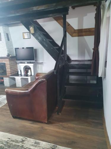 a living room with a couch and a staircase at La Hacienda in Cheţani