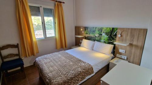 um quarto com uma cama, uma cadeira e uma janela em La Terracita del Bosque em El Bosque