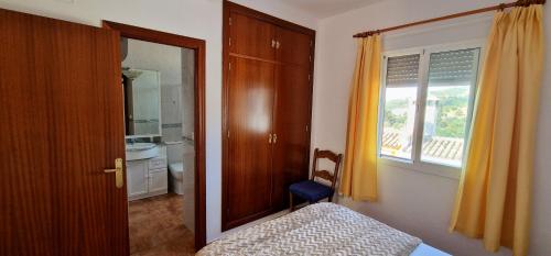 um quarto com uma cama, uma janela e um espelho em La Terracita del Bosque em El Bosque