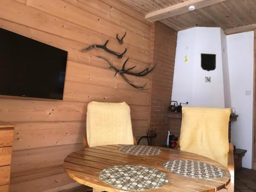 a dining room with a wooden wall with a table and chairs at Domek nieopodal rzeki Bug in Klepaczew