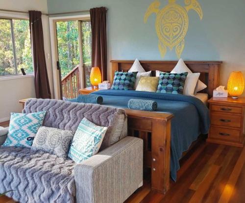 a bedroom with a bed and a couch at Deluxe Studio with Forest Views, Noosa Hinterland in Doonan