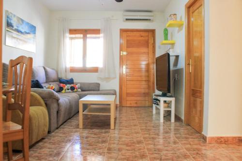 un soggiorno con divano e TV di Centrally located 2 bed apartment los alcazares a Los Alcázares