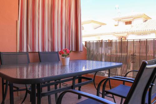 une table avec des chaises et une plante en pot sur un balcon dans l'établissement Centrally located 2 bed apartment los alcazares, à Los Alcázares