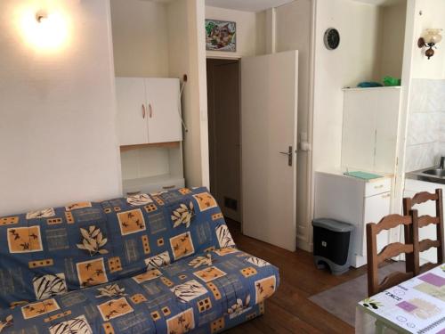 une petite chambre avec un lit et une cuisine dans l'établissement studio cabine Bagnères de Bigorre, à Bagnères-de-Bigorre