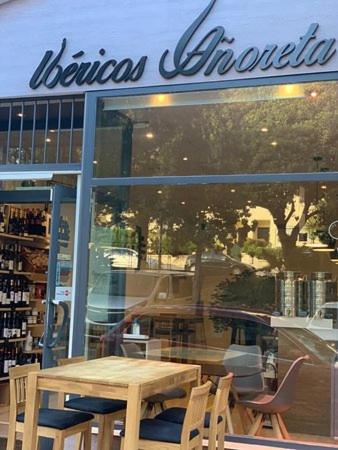 een tafel en stoelen voor een winkelraam bij Niña Sureña Home Añoreta Golf in Torre de Benagalbón