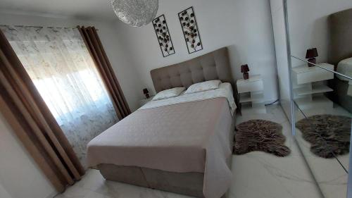 a bedroom with a large bed and a window at Penthouse Dream Look in Rogoznica