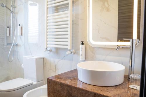 a white bathroom with a sink and a mirror at Hotel Leonessa in Volla