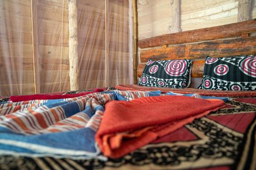 a bed with colorful blankets and pillows on it at Margarita Village kite school kalpitiya in Kalpitiya