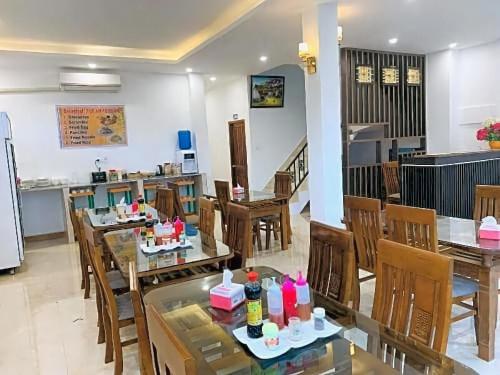 a dining room with tables and chairs and a kitchen at Downtown Vang Vieng Hotel in Vang Vieng