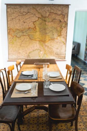 a wooden table with plates and glasses and a map at Schloss Hornegg in Preding