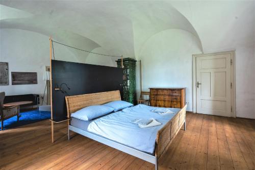 a bedroom with a large bed with blue sheets at Schloss Hornegg in Preding