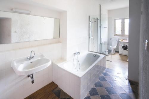 a white bathroom with a sink and a bath tub at Schloss Hornegg in Preding