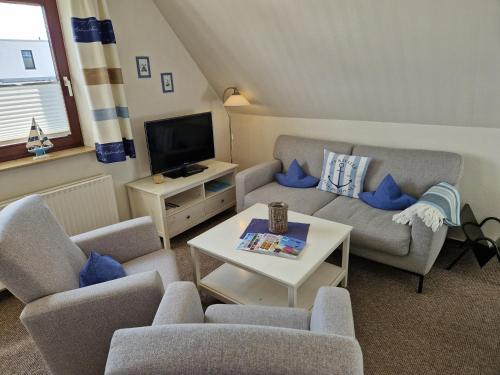 ein Wohnzimmer mit 2 Sofas und einem TV in der Unterkunft Appartementhaus Diana in Grömitz