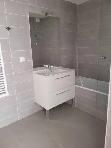 ein weißes Bad mit einem Waschbecken und einer Dusche in der Unterkunft Superbes appartements neufs à Montpellier in Montpellier