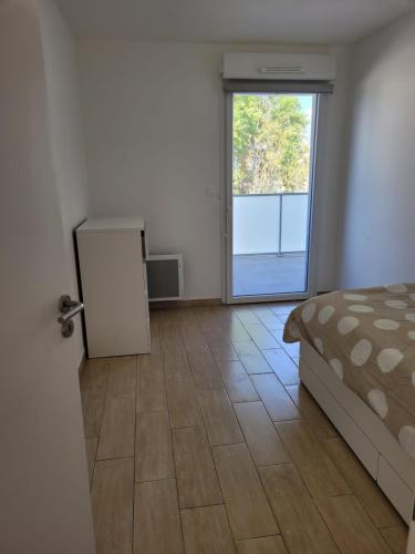 1 dormitorio con 1 cama y puerta corredera de cristal en Superbes appartements neufs à Montpellier, en Montpellier