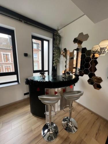 a kitchen with a bar with stools in a room at Aux trois univers in Verviers